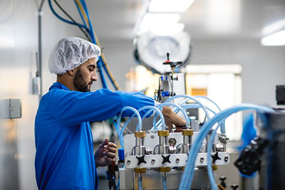 student wearing hairnet working on machinery