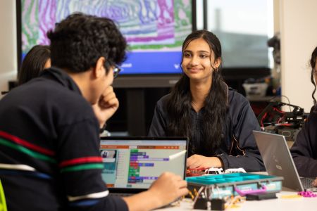 Image of girl smiling at a table of electronics